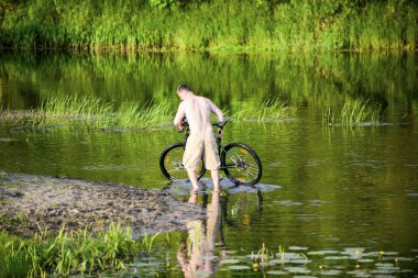 Adam nehre Snov Bisiklet yıkar