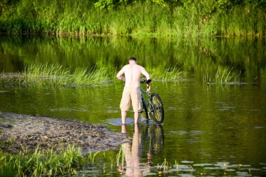 Adam nehre Snov Bisiklet yıkar