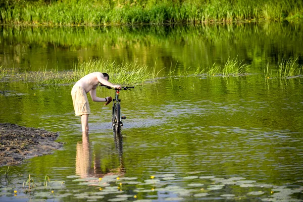 Adam nehre Snov Bisiklet yıkar
