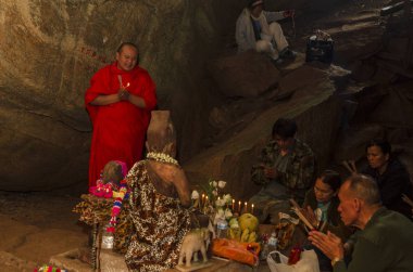 Bir Budist keşiş, Pai şehrinin yakınlarındaki bir mağarada ayin yapıyor. Tayland. Nisan 2014