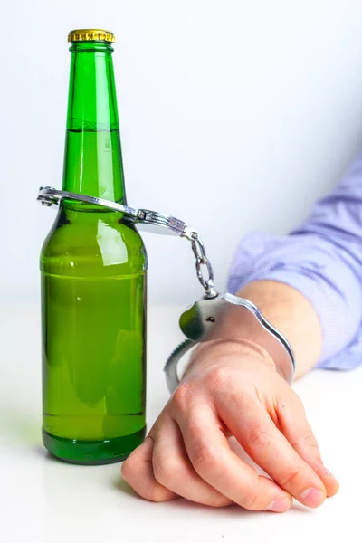 Стакан пива с наручниками — стоковое фото
