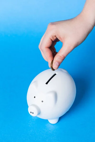Putting coin into piggy bank — Stock Photo, Image