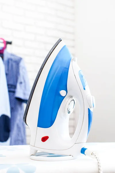 Electric iron with shirts — Stock Photo, Image