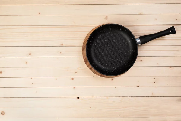 Cast iron pan on wooden table — Stock Photo, Image