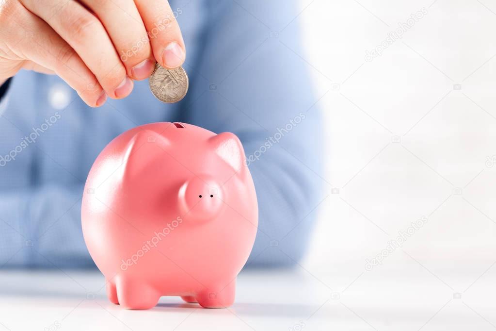 Putting coin into piggy bank