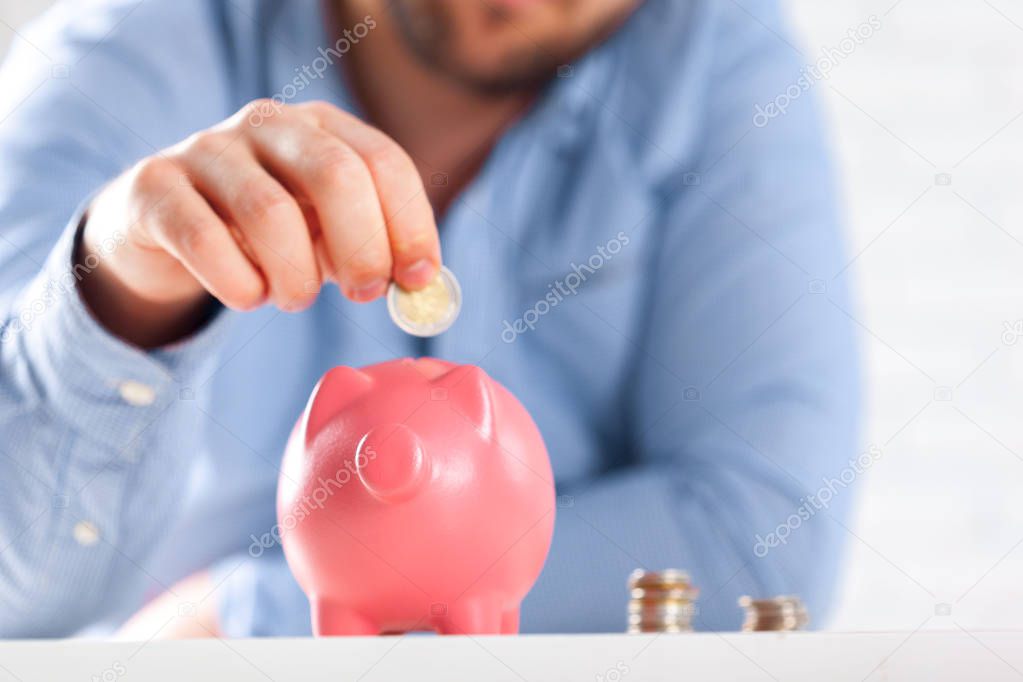 Putting coin into piggy bank