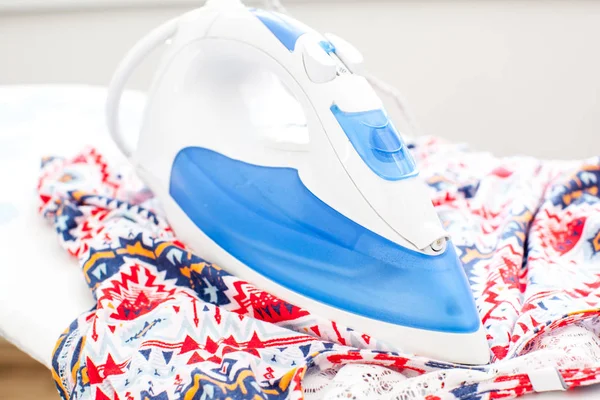 Electric iron on board at work — Stock Photo, Image