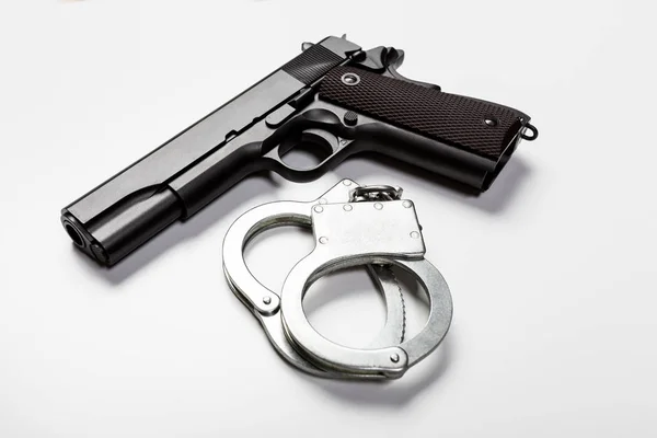 Pistole und Handschellen auf weiß — Stockfoto
