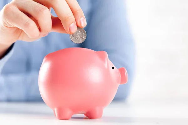 Att sätta mynt i Piggy Bank — Stockfoto