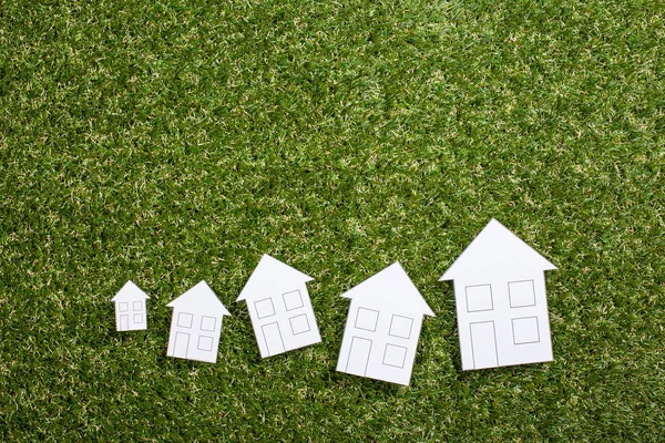 Паперові будинки на зеленій траві — стокове фото