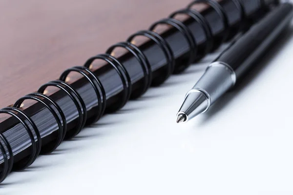 Pluma y cuaderno en la mesa — Foto de Stock