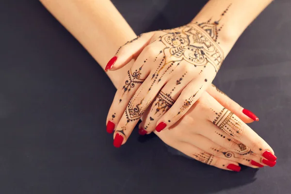 Красные маникюрные руки с Мехнди — стоковое фото