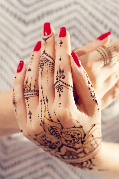Röd manikyrerade händer med Mehndi — Stockfoto