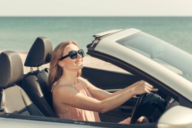 Genç kadın bir araba sahilde