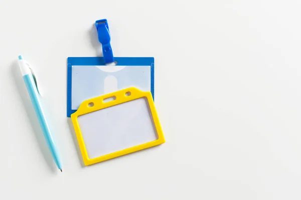 Name tag and a pen on white background