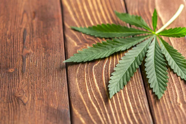 木のテーブルの上の大麻の葉 — ストック写真
