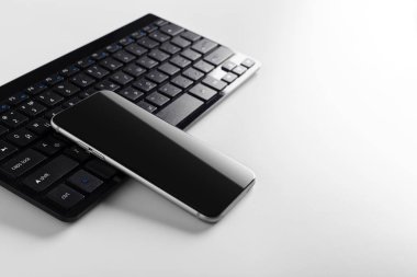 Masanın üstünde hareket eden telefon ile klavye