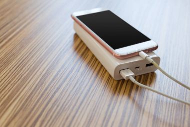 powerbank ve ahşap masa, modern araçlar arka plan üzerinde cep telefonu 