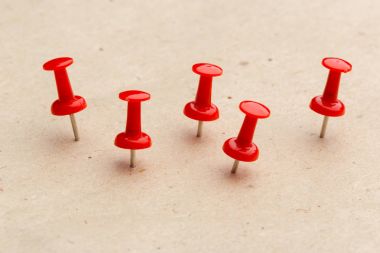 Corkboard arka plan üzerinde kırmızı iğneler