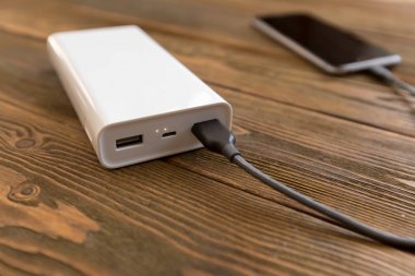 powerbank ve ahşap masa, modern araçlar arka plan üzerinde cep telefonu 