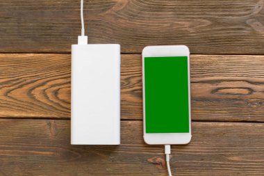 powerbank ve ahşap masa, modern araçlar arka plan üzerinde cep telefonu 