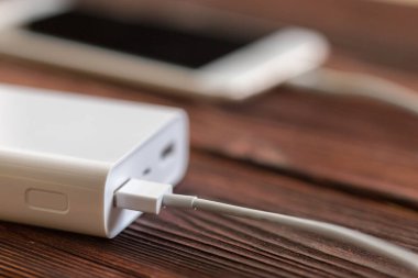 powerbank ve ahşap masa, modern araçlar arka plan üzerinde cep telefonu 