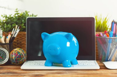 Domuz para Kasası ahşap masa üstünde laptop ile