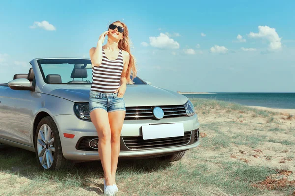 Arabanın yakınında sahilde rahatlatıcı kadınla