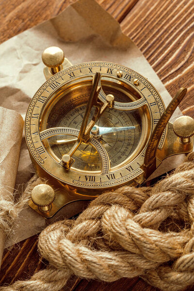 Компас и веревка на деревянном столе, закрыть
.