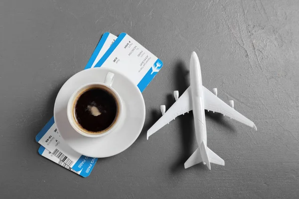 Airplane toy with coffee cup and tickets on table