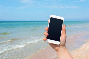 Kumsalda Smartphone kullanarak güzel kadın eli