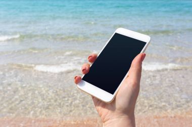 Kumsalda Smartphone kullanarak güzel kadın eli