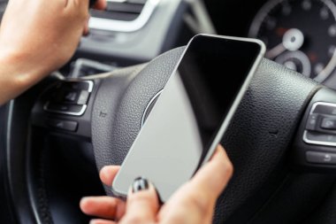kadın sürücü bir cep telefonu kullanarak