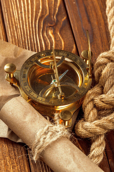 Компас и веревка на деревянном столе, закрыть
.