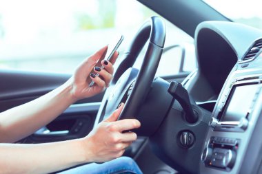 kadın sürücü bir cep telefonu kullanarak