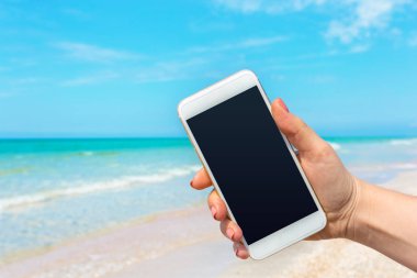 Kumsalda Smartphone kullanarak güzel kadın eli