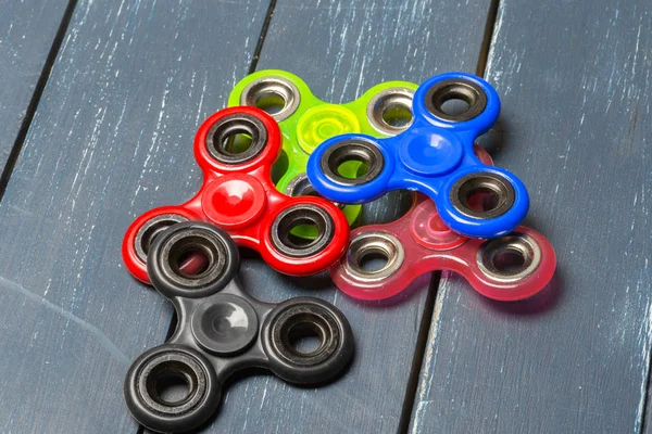 fidget hand spinner stress relieving toys on a wooden background