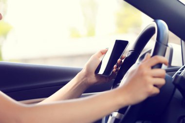 kadın sürücü bir cep telefonu kullanarak