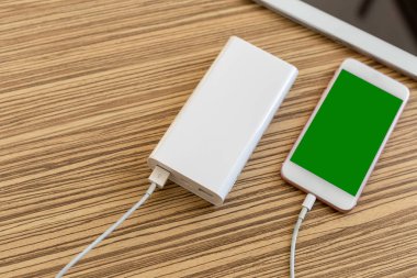 powerbank ve ahşap masa, modern araçlar arka plan üzerinde cep telefonu 