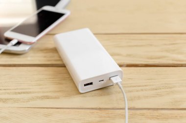 powerbank ve ahşap masa, modern araçlar arka plan üzerinde cep telefonu 