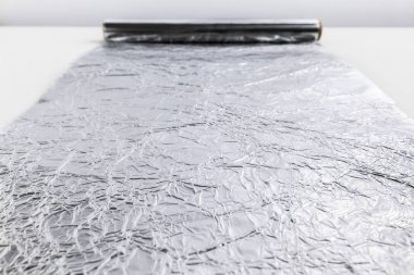 Beyaz arka plan üzerinde izole alüminyum folyo rulo