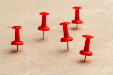 Corkboard arka plan üzerinde kırmızı iğneler