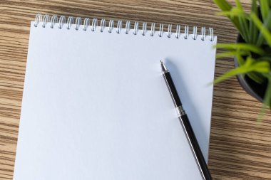 Kalem ve bir masada boş sketchbook
