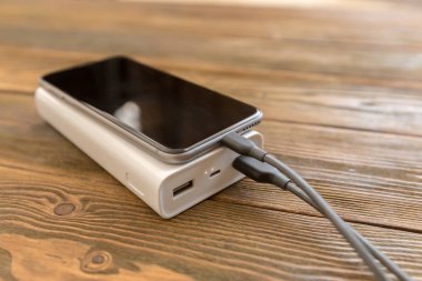powerbank ve ahşap masa, modern araçlar arka plan üzerinde cep telefonu 