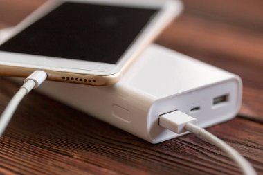 powerbank ve ahşap masa, modern araçlar arka plan üzerinde cep telefonu 