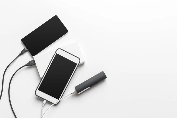 Smartphones Rechargeant Avec Banque Alimentation Sur Fond Table — Photo