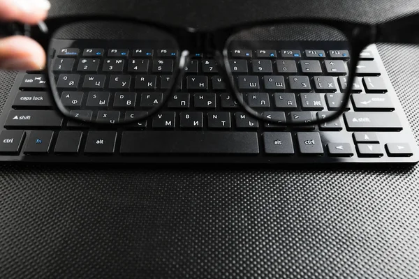 眼鏡とテーブルの上のキーボード — ストック写真