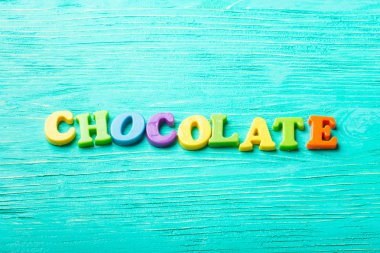 Turkuaz ahşap masa üzerinde birden çok renkli harfler