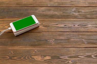 powerbank ve ahşap masa, modern araçlar arka plan üzerinde cep telefonu 