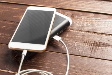 Tablo arka plan üzerinde güç banka ile şarj Smartphone